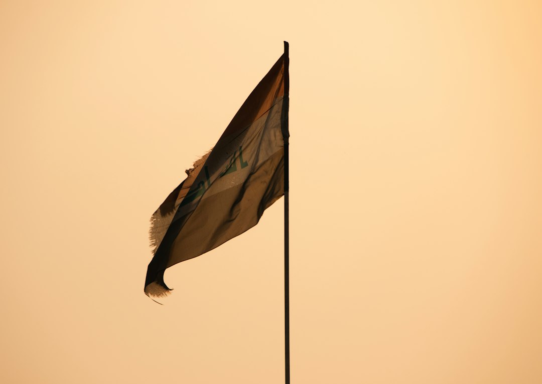 Iraq’s national flag flying in daylight, representing the country as U.S. forces complete their military withdrawal.
