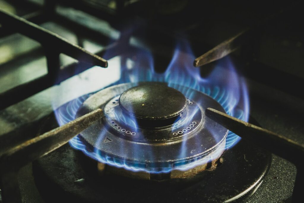 Blue natural gas flame on a household stove, illustrating rising gas and energy costs