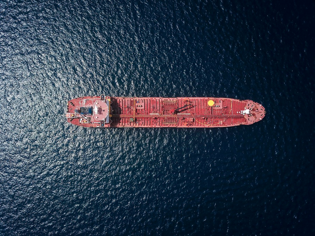 Aerial view of an oil tanker at sea, illustrating global energy trade affected by sanctions. Photo by Shaah Shahidh on Unsplash.
