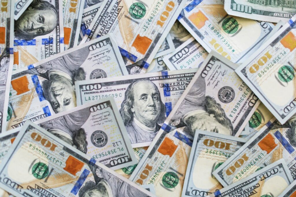 Close-up of a U.S. 100-dollar bill illustrating interest rates, inflation and borrowing costs. Photo by Giorgio Trovato on Unsplash.